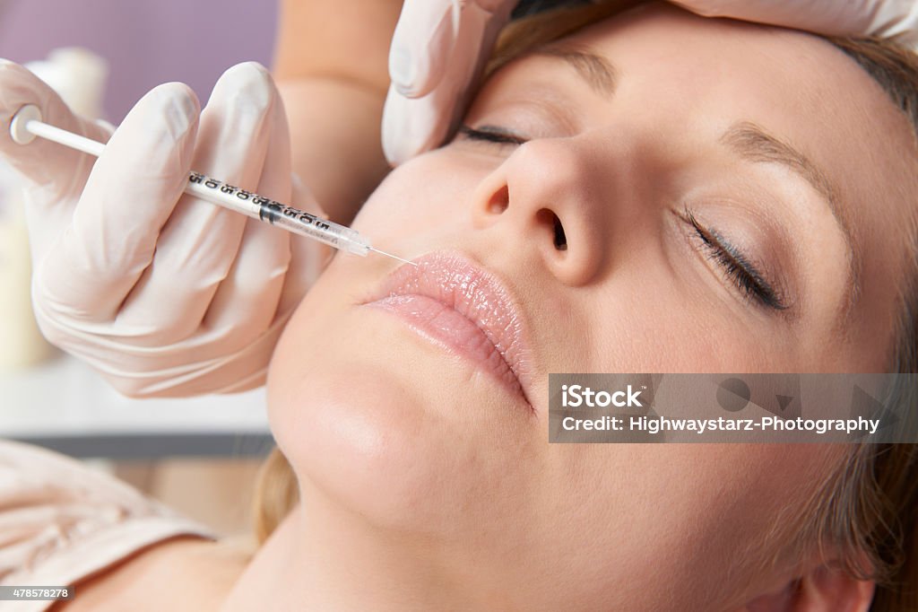 Frau, die Injektion In Ihre Lippen und Schönheitsbehandlung - Lizenzfrei Botulinumtoxin-Spritze Stock-Foto