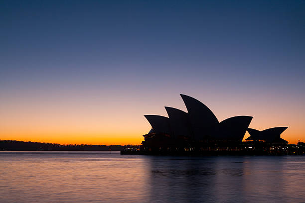 Sydney, Australia - August 21, 2009: Sydney Opera House is silhouetted against a brilliant winter sunrise.