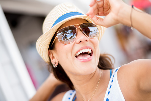 Portrait of a summer woman on holidays looking happy wearing a hat and sunglasses