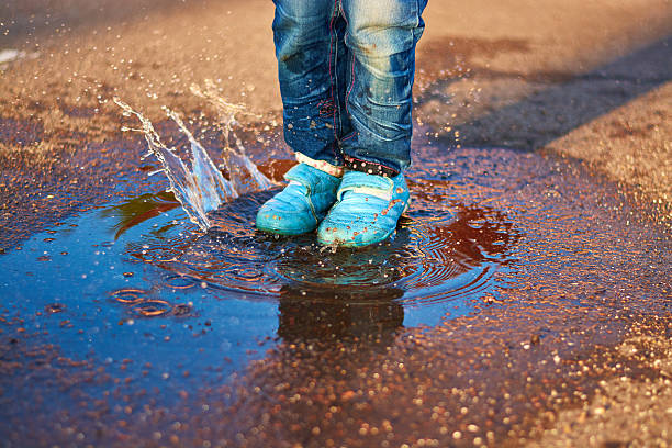 istock The child jumps in a puddle 478582610