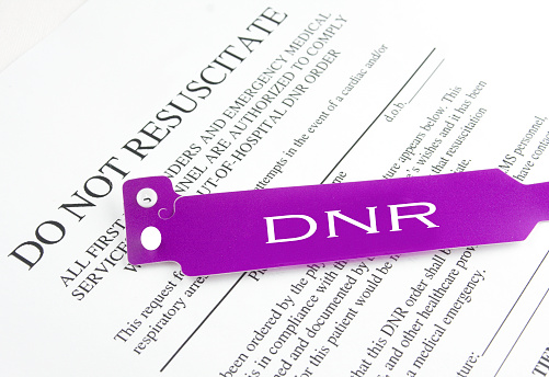 Do not resuscitate purple bracelet on top of a hospital medical form