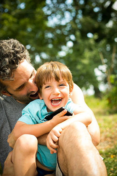 Dad and young son playing together in the park.