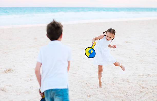 Happy family playing beach volleyball by the river on a sunny day. lifestyle. Summer holidays.