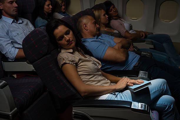 Flight passengers sleep plane cabin night travel stock photo