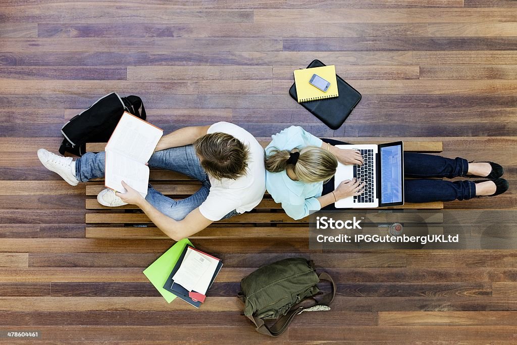 Top view of male and female university students studying Top View Of University Students Studying Hot Desking Stock Photo