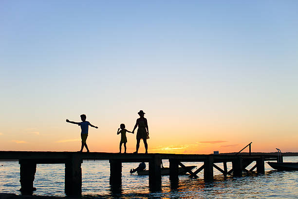 istock Family sunset silhouettes 478604603