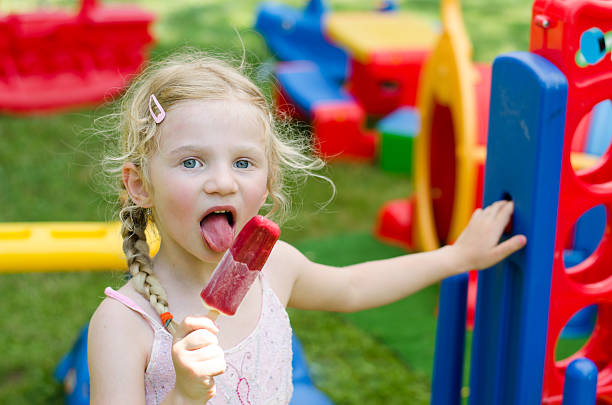 girl eating ice lolly stock photo