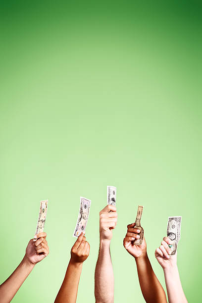 istock Five hands hold up US banknotes against green background 478607041