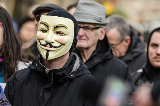 Halifax, Canada - December 19, 2014: A man in a Guy Fawkes mask joins protestors outside the Henry Hicks Building at Dalhousie University after the discovery of a Facebook group allegedly operated by Dalhousie Dentistry students that contained comments about drugging and raping women, as well as other misogynistic and hateful posts.