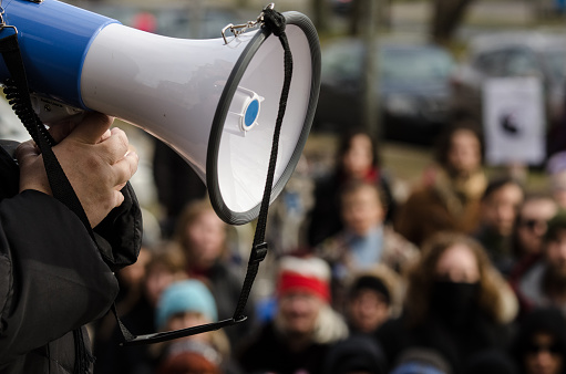 Halifax, Canada - December 19, 2014: A woman speaks into a megaphone at a protest outside Dalhousie University after the discovery of a Facebook group allegedly operated by Dalhousie Dentistry students that contained comments about drugging and raping women, as well as other misogynistic and hateful posts.