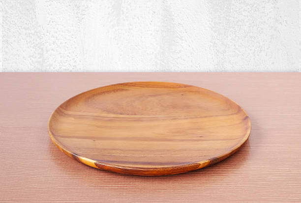 istock Empty round wooden tray on table over white wall. 478627330