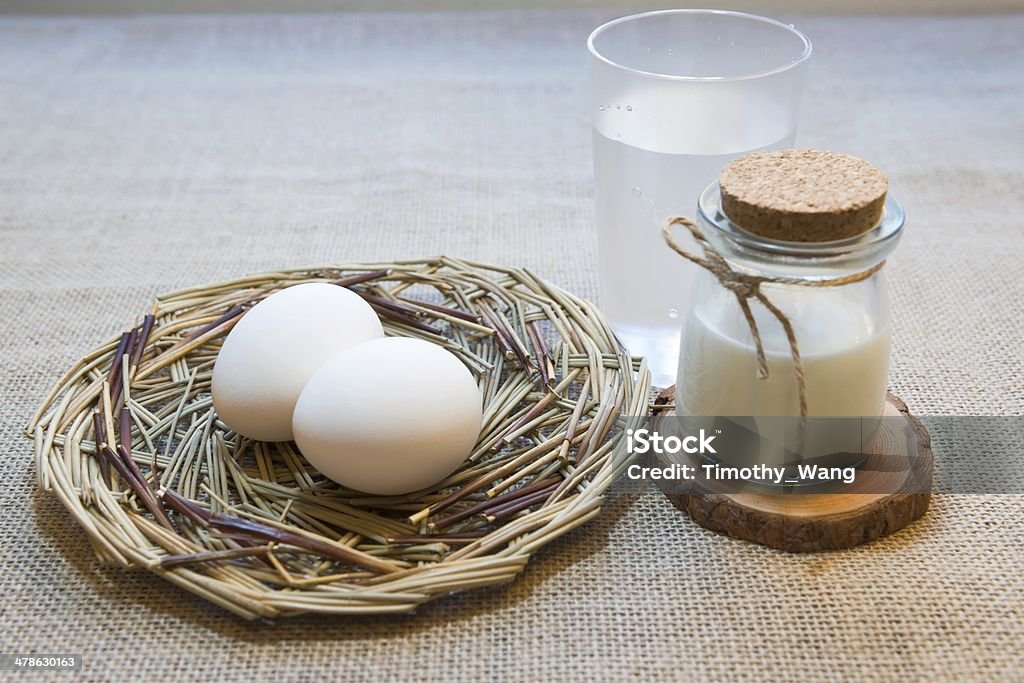 Eggs in nest with milk Two eggs in the nest near a bottle of milk. Agriculture Stock Photo