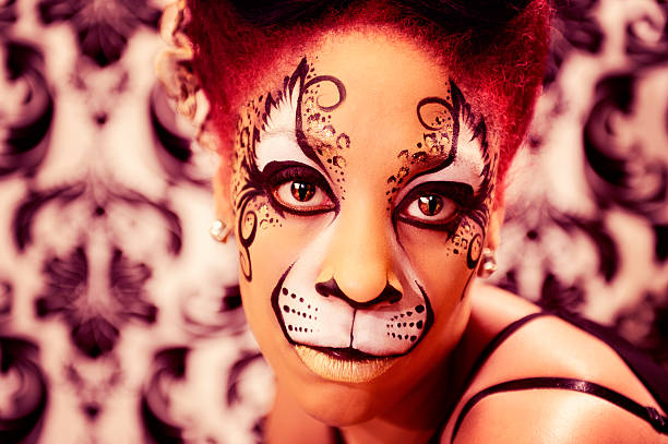 Halloween beauty close-up photography of female smiling mouth. Beautiful woman adorned with Santa Muerte makeup. Celebration of Day of the Dead. Skull painted on her face. Make-up with rhinestones.