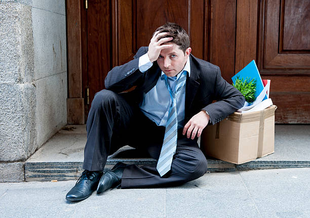 istock frustrated business man on street fired carrying cardboard box 478634205