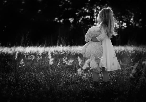 smiling adorable child hugging teddy bear isolated on white and looking at camera