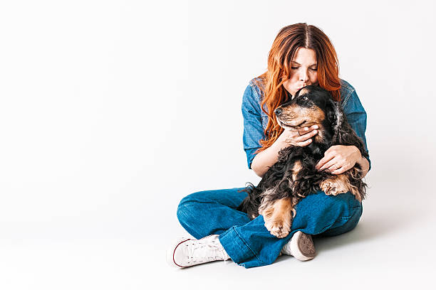 Beautiful redhead woman on her 40s with her dog Beautiful redhead woman on her 40s playing with her dog a English Cocker Spaniel dog kiss stock pictures, royalty-free photos & images