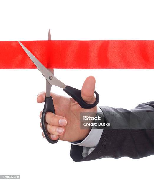 Hand Of Businessman In Suit Cutting Red Ribbon Stock Photo - Download Image Now - Ribbon Cutting, 2015, Adult