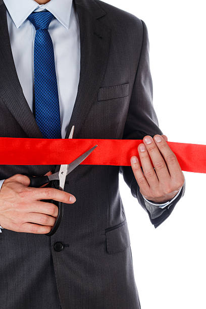 istock Businessman in suit cutting red ribbon 478639534