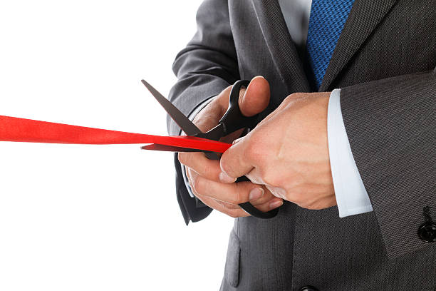 istock Businessman in suit cutting red ribbon 478639538