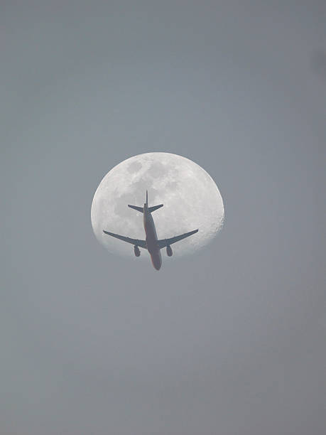 istock Passenger plane flying against the moon, low angle view 478641071