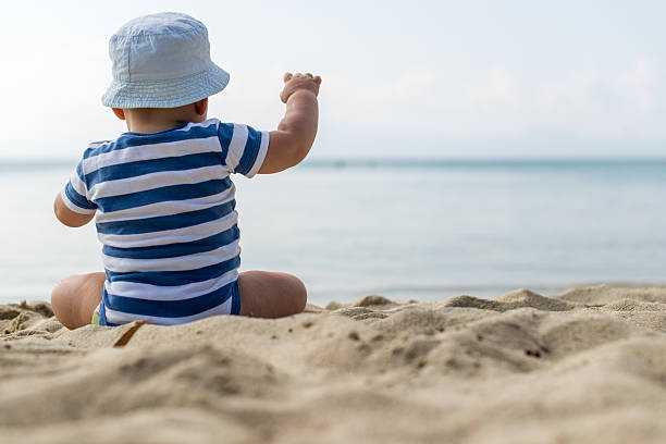 istock Little baby boy sitting on the sand 478649640