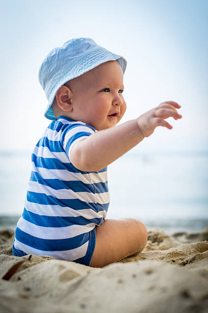 istock Little baby boy sitting on the sand 478649672