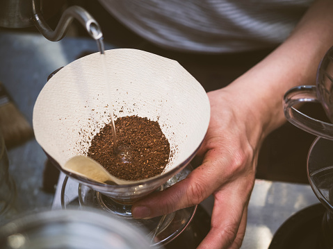 Barista pouring water on coffee ground with filter, Hand drip making coffee