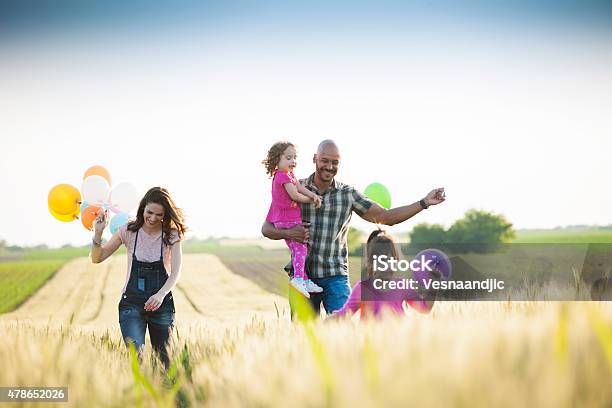 Beautiful Multi Ethnic Family Running Through Wheat Field Stock Photo - Download Image Now