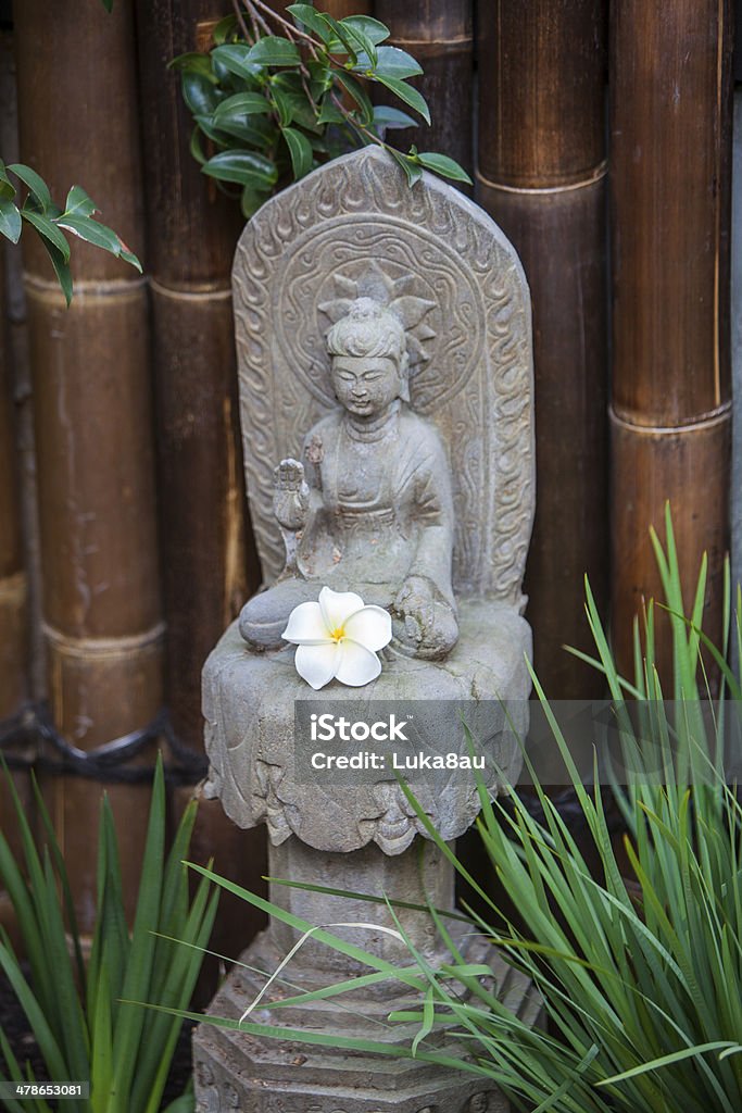 Estátua de Buda no jardim com flor de frangipani - Foto de stock de Bambu royalty-free