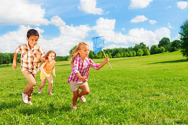 Two Asian toddler girl are happily playing bubbles in a garden park.