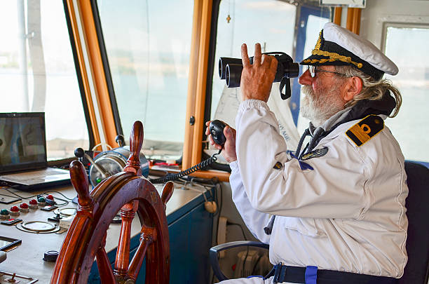 Observation Old experienced captain observes using binoculars by left hand and holding radio comunication equipment by right hand team captain stock pictures, royalty-free photos & images