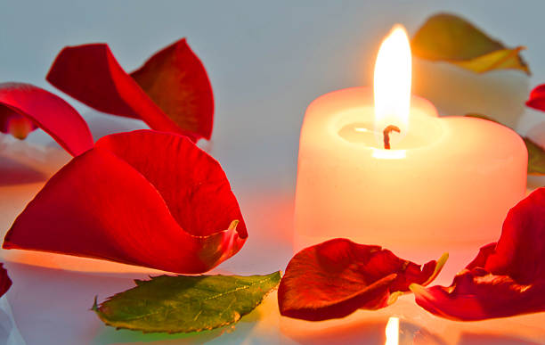 istock burning candle in rose petals in heart shape 478656781