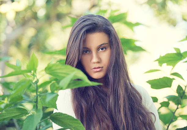 Portrait of a sophisticated lady surrounded by greenery and natural beauty in an elegant park landscape