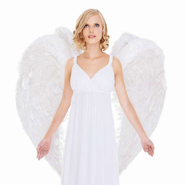 Photograph of a 15 months girl in a white dress with angel wings.