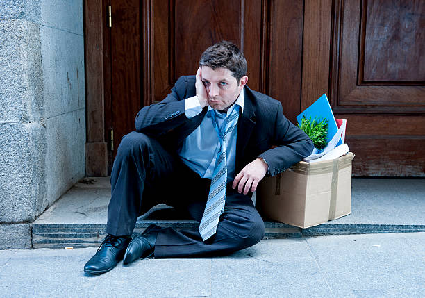 istock frustrated business man on street fired carrying cardboard box 478664007