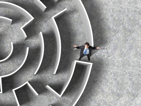 Top view of successful businessman lost in labyrinth