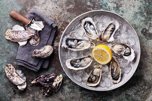istock Opened Oysters on metal plate with ice and lemon 478668424