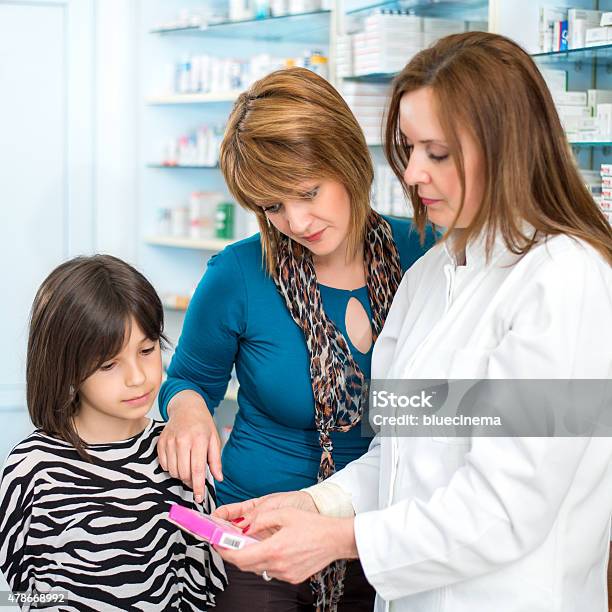 Farmacéutico Que Medicamento A Una Madre E Hija Foto de stock y más banco de imágenes de 2015 - 2015, 30-39 años, Adulto