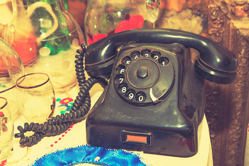 Vintage rotary telephone dial, slightly cross processed close up.