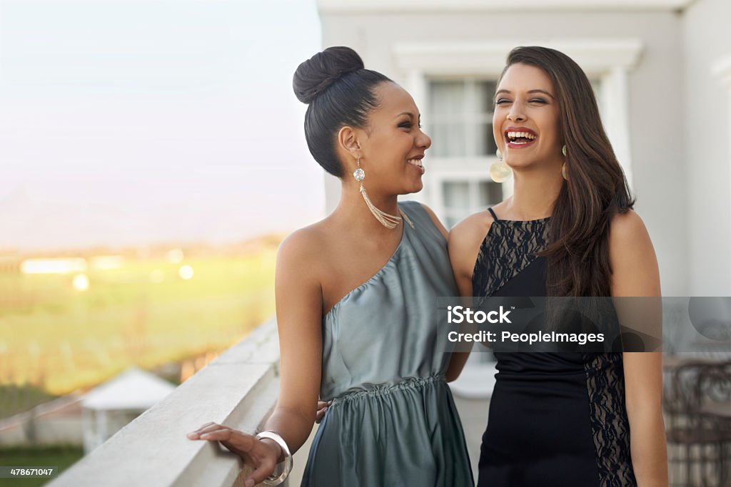 Excitement before the prom Two young women in evening wear standing on a balcony Formalwear Stock Photo