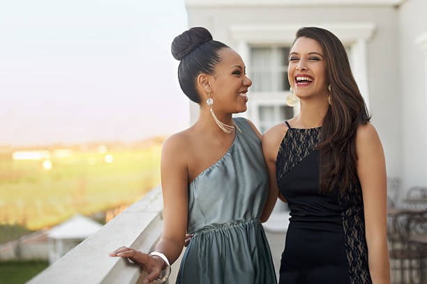 Excitement before the prom Two young women in evening wear standing on a balcony black tie events stock pictures, royalty-free photos & images