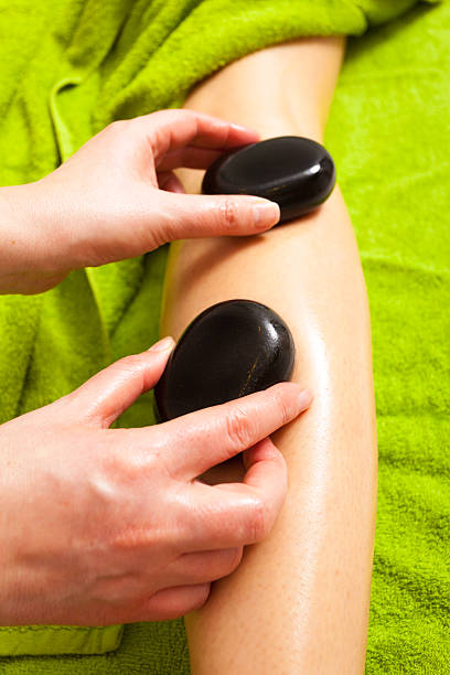 ビューティーサロンも備えています。 女性スパのホットストーンマッサージレッグス - massage therapist stone spa treatment working ストックフォトと画像