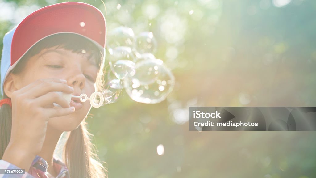 Blowing fragile bubbles Girl blowing soap bubbles in summer 10-11 Years Stock Photo