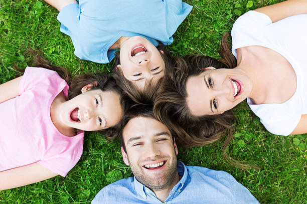 istock Family lying on grass smiling 478676598