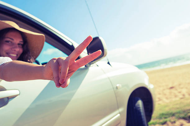 istock Woman making a peace sign while driving 478676967
