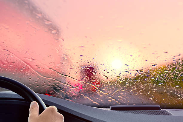 Driving onto a Highway at Sunset Driving onto a Highway at Sunset. Rainy weather rush hour traffic jam scene - poor view caused by heavy rain and back light. truck in rain stock pictures, royalty-free photos & images