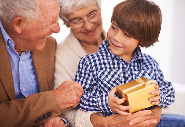 lepiej otwórz i zobacz, co to jest. - grandmother giving gift child zdjęcia i obrazy z banku zdjęć