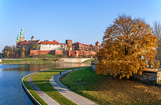 Vistula river bend, promenades, autumn tree and Wawel castle at sunset in Krakow, Poland