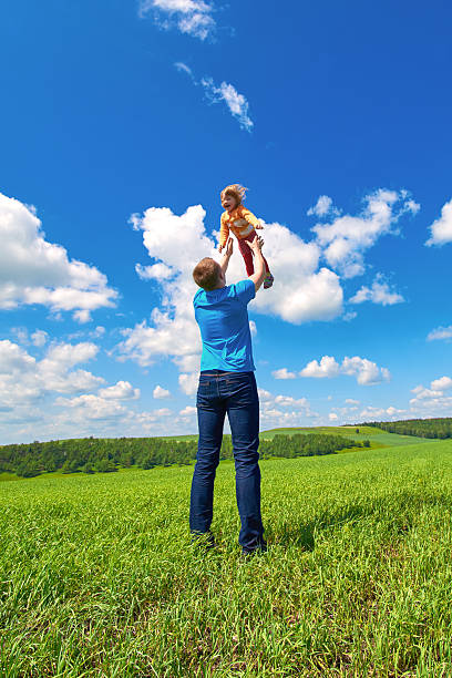 istock Father throws daughter up in the air 478689968