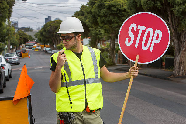 istock worker talking to radio and holding stop sign 478690167
